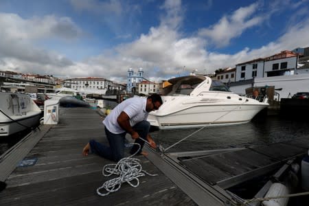 A man reinforces with ropes the mooring of his boat at a port before the arrival of Hurricane Lorenzo in Angra do Heroismo in the Azores islands