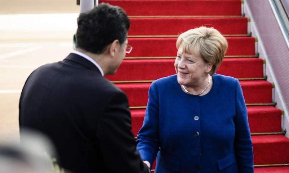 Qin Gang, then vice-minister for foreign affairs, greets Angela Merkel on arrival in China in 2018