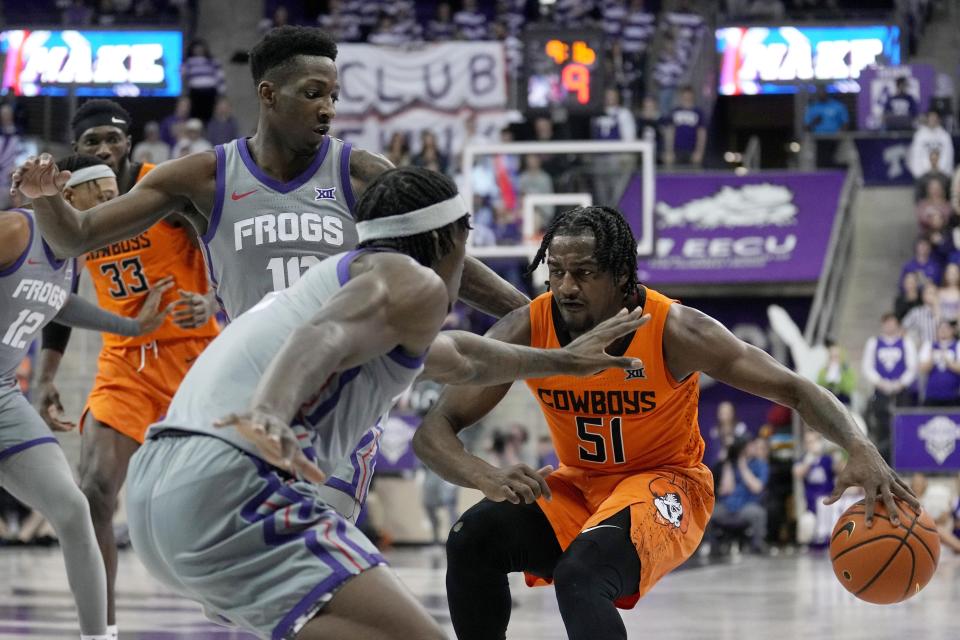 Oklahoma State guard John-Michael Wright (51) works against TCU forward Emanuel Miller, front, and Damion Baugh, left, in the first half of an NCAA college basketball game, Saturday, Feb. 18, 2023, in Fort Worth, Texas. (AP Photo/Tony Gutierrez)