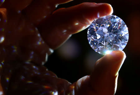 REFILE - CORRECTING YEAR An assistant holds a 102.34 carat white diamond at Sotheby's auction house in London, Britain February 8, 2018. REUTERS/Hannah McKay