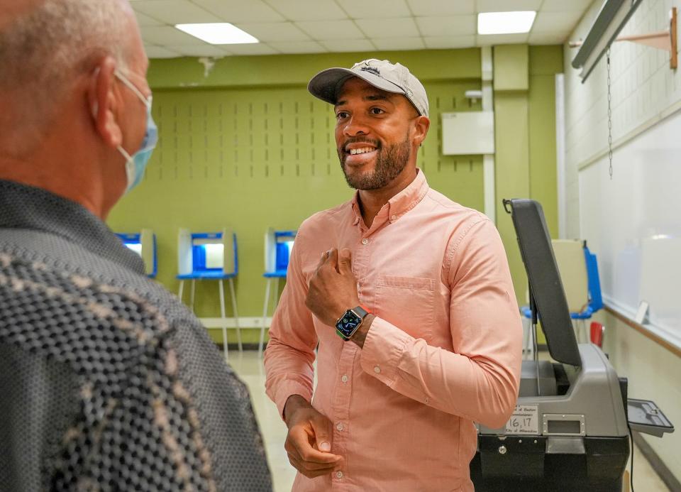 Mandela Barnes speaks with Gary Sprong as he places an "I Voted" sticker on his chest Tuesday during the partisan primary at Green Tree Preparatory Academy, 6850 N. 53rd St., Milwaukee. Barnes is the Democratic candidate running for U.S. Senate.