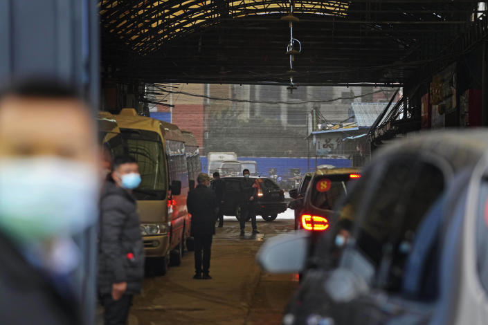 FILE - In this file photo dated Sunday, Jan. 31, 2021, a convoy of vehicles carrying the World Health Organization team enters the interior of the Huanan Seafood Market on the third day of field visit in Wuhan in central China. International scientists have examined previously unavailable genetic data from samples collected at a market in China close to where the first human cases of COVID-19 were detected and said they have found suggestions the pandemic originated from animals, not a lab. (AP Photo/Ng Han Guan, File)
