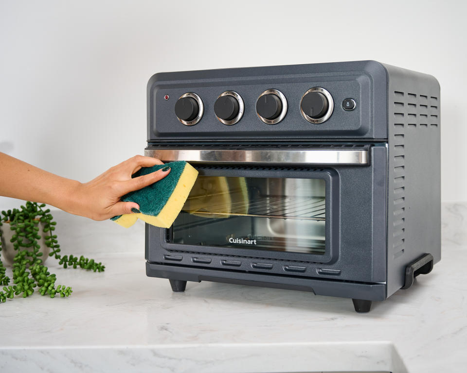 Christina Chrysostomou cleaning outside of Cuisinart Air Fryer Toaster Oven