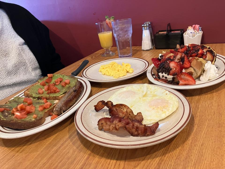 Avocado toast with scrambled eggs on the side (normally served poached) alongside sausage links. Over easy eggs and bacon are accompanied by Michael A.M.'s stuffed French toast, which are filled with homemade sweet cream cheese, chocolate chips and strawberries, topped with strawberry sauce and whipped cream.