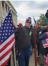 A photo from the Jan. 6, 2021 insurrection at the U.S. Capitol that the U.S. Department of Justice says shows Dustin B. Thompson of Columbus with a wooden coat rack he is accused of stealing from inside the Senate wing.