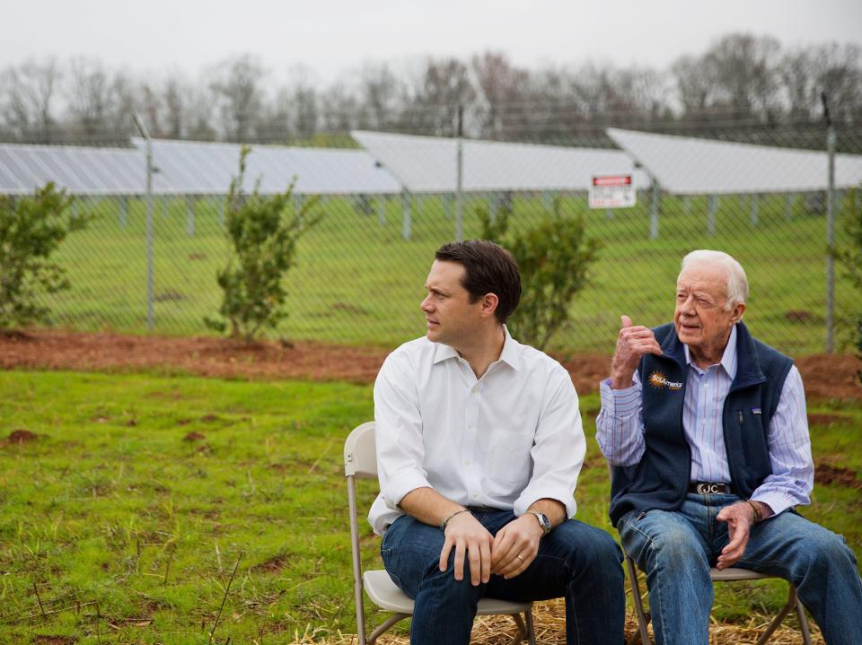 Jimmy Carter with his grandson Jason Carter sitting in front of solar panels in Georgia