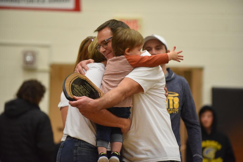 Hudson head coach Scott Marry hugs members of his family after receiving his plaque as an inductee into the Lenawee County Wrestling Hall of Fame as part of Friday's Lenawee County All-Star Wrestling meet at Adrian College.