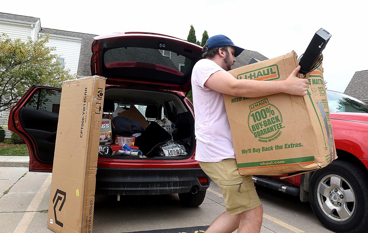 Chris Mitchell moves items into his apartment he shares with another renter on Monday off of Aaron Drive.