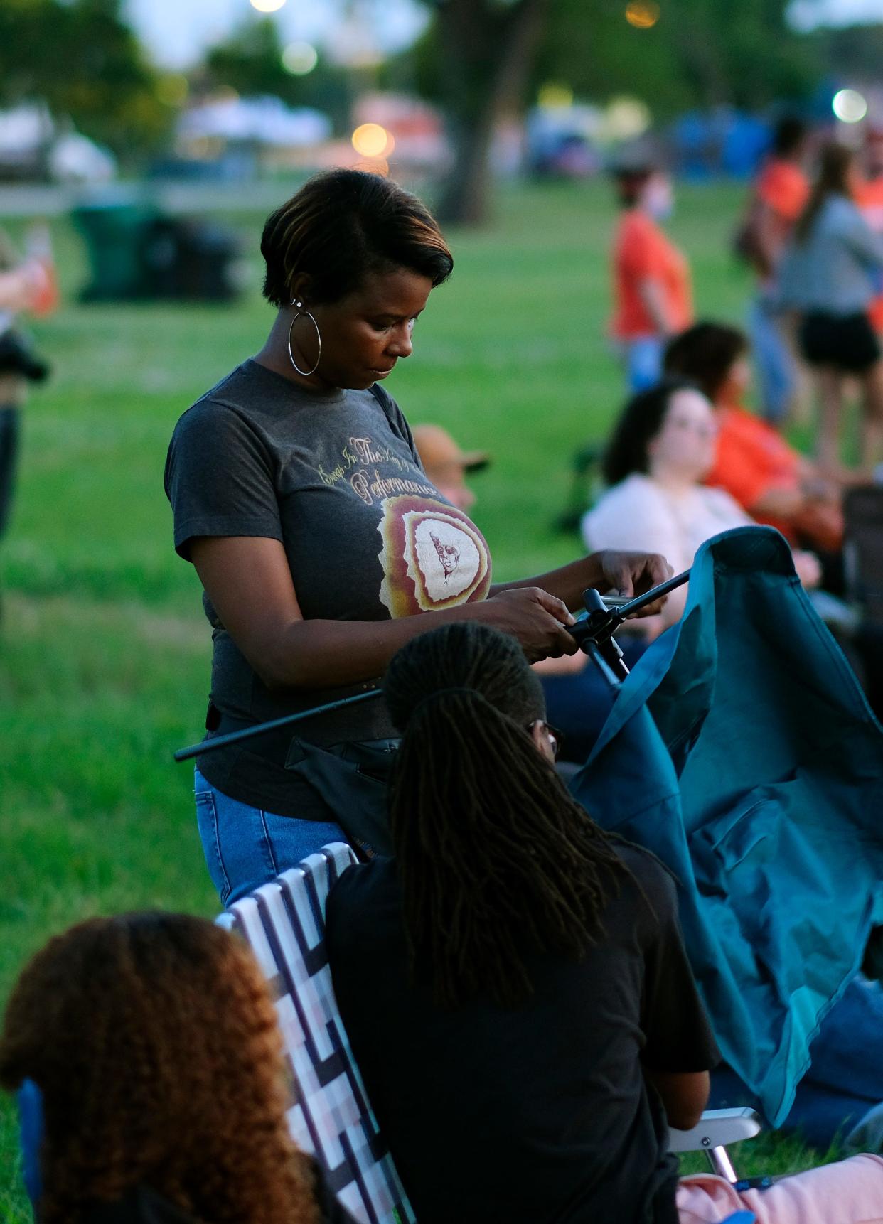 Oklahoma City Councilwoman Nikki Nice sets up a chair during deadCenter Film Festival outdoor concert and screening at Booker T. Washington Park Saturday, June 12, 2021.