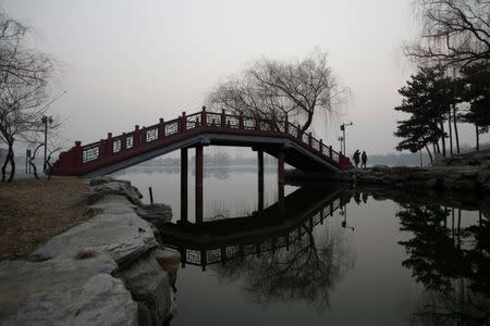 People walk through a bridge at the Old Summer Palace in smog on a polluted day as a red alert issued for air pollution in Beijing, China December 17, 2016. REUTERS/Jason Lee