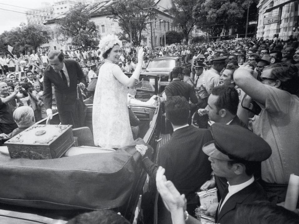 The Queen waves from her motorcade in Salvador, Brazil, in 1968.