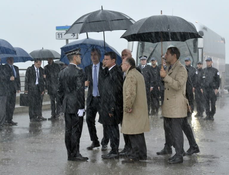 French Prime Minister Manuel Valls (C) and Interior Minister Bernard Cazeneuve (foreground 2ndR) visit the Eurotunnel terminal in the northern French port of Calais, on August 31, 2015