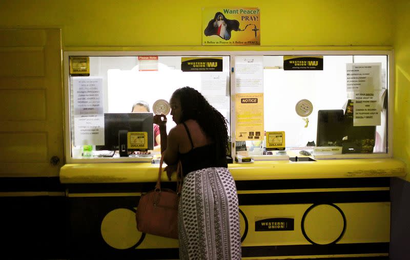 FILE PHOTO: A woman uses a money wire service at a supermarket in Belize City