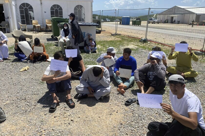 This image provided by Muhammad Arif Sarwari, shows Afghans who fled the Taliban takeover of their country staging a protest at Camp Bondsteel in Kosovo, Wednesday, June 1, 2022. The camp is used to house people who have not been allowed to enter the U.S. because of security concerns. Some of the Afghans have been waiting for months at the base while authorities try to resolve their fate, which officials say may involve sending them to another country for resettlement. (Muhammad Arif Sarwari via AP)