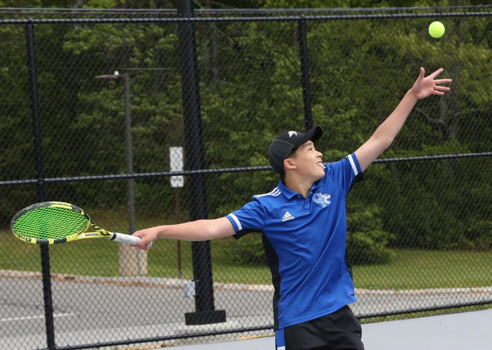 Oyster River's James Li delivers a serve at No. 4 singles in Thursday's Division II boys tennis quarterfinal against Winnacunnet.