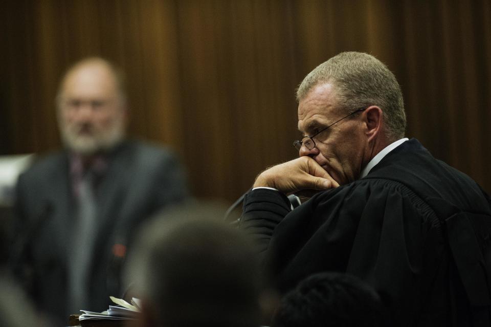 Forensic investigator, Roger Dixon, back left, is questioned by state prosecutor Gerrie Nel, foreground, during the murder trial of Oscar Pistorius in court in Pretoria, South Africa, Wednesday, April 16, 2014. Pistorius is charged with the murder of his girlfriend, Reeva Steenkamp, on Valentines Day in 2013. (AP Photo/Gianluigi Guercia, Pool)