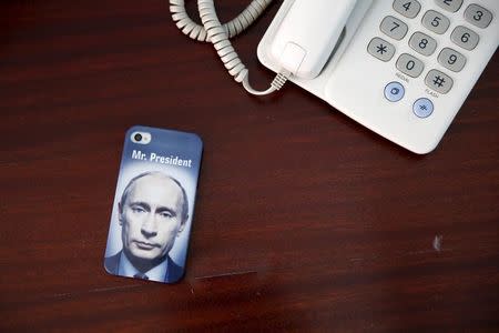 A mobile phone cover with a picture of Russian President Vladimir Putin and which reads "Mr President" is seen in this photo illustration taken a in hotel room in Kazan, Russia, July 30, 2015. REUTERS/Stefan Wermuth