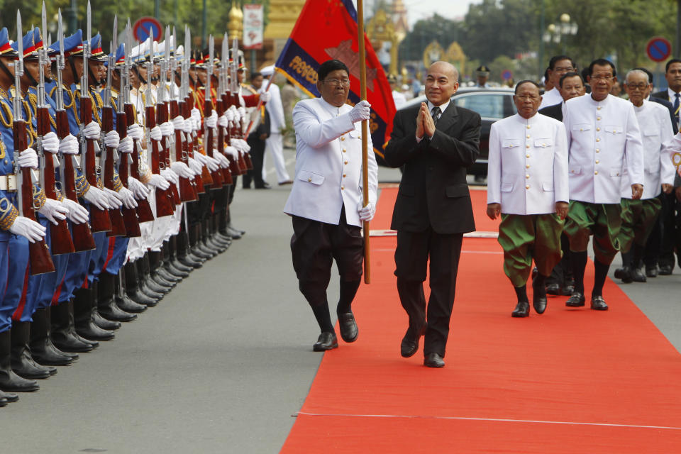 Cambodia's King Norodom Sihamoni, center, reviews honorary troop in front of the National Assembly in Phnom Penh, Cambodia, Wednesday, Sept. 5, 2018. Cambodian King Norodom Sihamoni on Wednesday presided over the opening of the first session of National Assembly to ensure long-ruling Prime Minister Hun Sen, third right, another term after his party swept election in late July. (AP Photo/Heng Sinith)