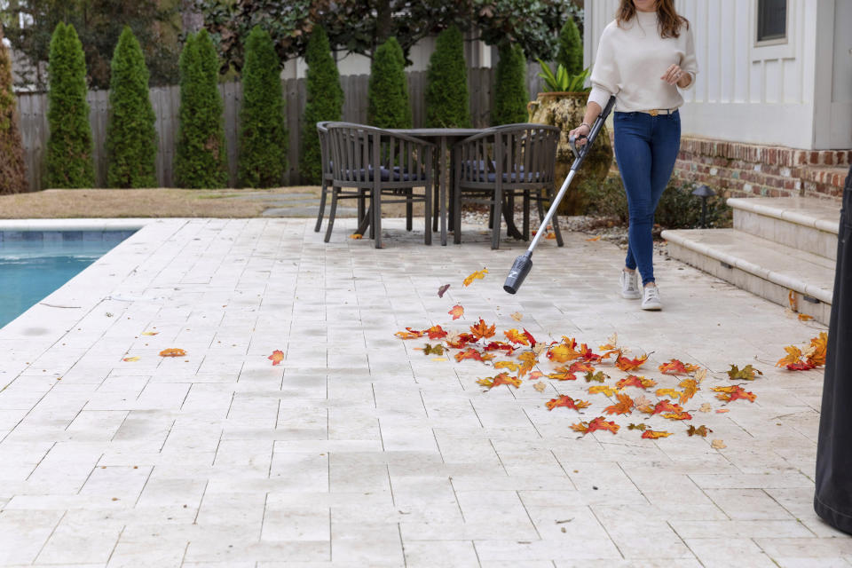 This image provided by ZoomBroom shows a lightweight, cordless ZoomBroom stick blower in use. (ZoomBroom via AP)