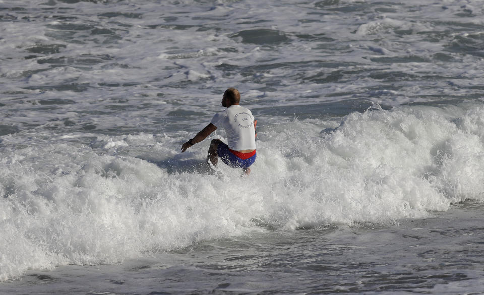 A police officers jumps into the sea on a deserted beach in Biarritz, France, on the first day of the G-7 summit, Saturday, Aug. 24, 2019. U.S. President Donald Trump and the six other leaders of the Group of Seven nations will begin meeting Saturday for three days in the southwestern French resort town of Biarritz. France holds the 2019 presidency of the G-7, which also includes Britain, Canada, Germany, Italy and Japan. (AP Photo/Markus Schreiber)