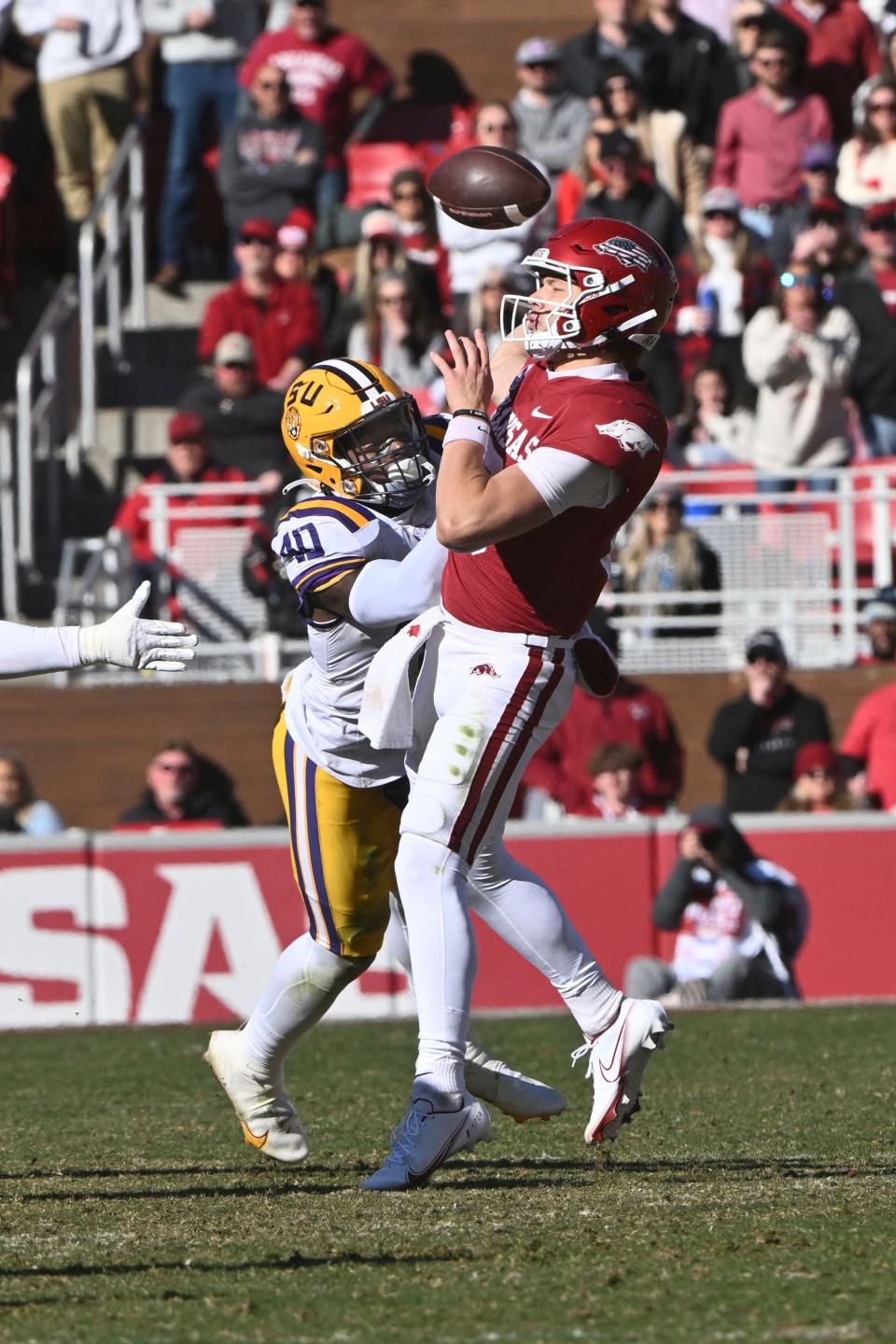 LSU linebacker Harold Perkins Jr. (40) knocks the ball away from Arkansas quarterback Cade Fortin (10) during the second half of an NCAA college football game Saturday, Nov. 12, 2022, in Fayetteville, Ark. The play was called a fumble and recovery by LSU but was reversed after officials reviewed the play. (AP Photo/Michael Woods)