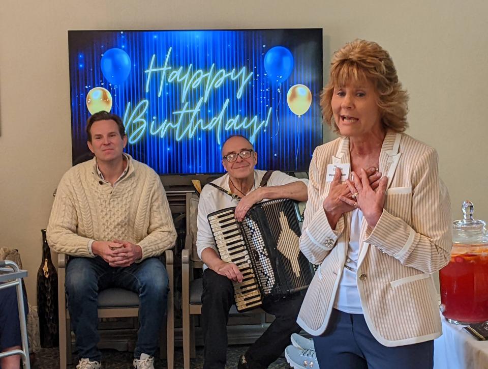 Wendy Switzer, Inn at Edgewood administrator, offers a heartfelt 101st birthday tribute to new resident John B. Robinson as Portsmouth Mayor Deaglan McEachern and musician Gary “Creekman” Sredzienski look on.