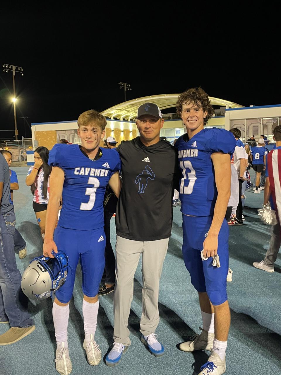 (From left)-Eli Asay, new Carlsbad High School head football coach Cale Sanders and Dane Naylor pose for a picture after a football game in 2022. Sanders was named head coach on Jan. 30, 2023.