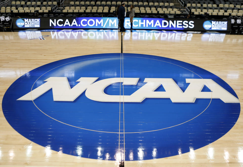 FILE - In this March 18, 2015, file photo, an NCAA logo is displayed at center court as work continues at The Consol Energy Center in Pittsburgh, for the NCAA college basketball second and third round games. A Los Angeles jury has rejected a claim by the widow of a former USC football player who said the NCAA failed to protect him from repeated head trauma that led to his death. The jury found Tuesday, Nov. 22, 2022, that the NCAA was not negligent in the death of Matthew Gee.(AP Photo/Keith Srakocic, File)