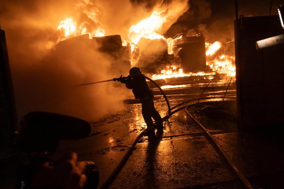 Firefighters extinguish a fire after a Russian attack on a residential neighborhood in Kharkiv (AP)