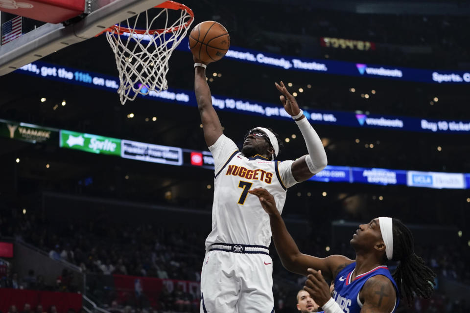 Denver Nuggets guard Reggie Jackson, left, prepares to dunk past Los Angeles Clippers guard Terance Mann, right, during the first half of an NBA basketball game, Monday, Nov. 27, 2023, in Los Angeles. (AP Photo/Ryan Sun)