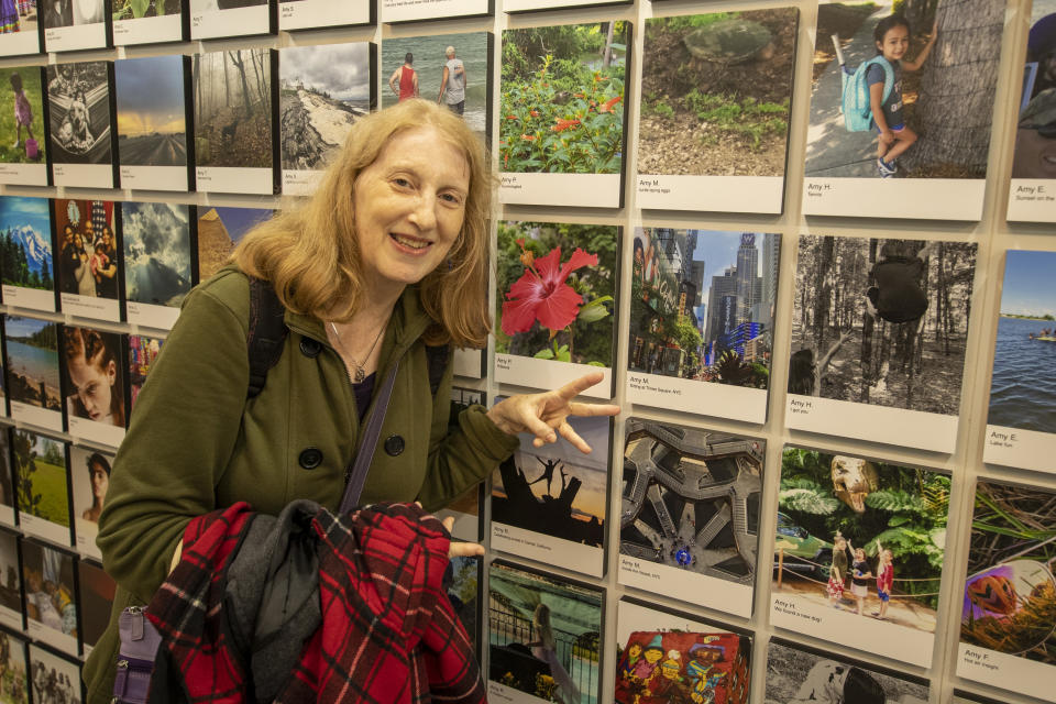 Photographer Amy of Queens, N.Y., gestures toward her photos selected to be in the exhibit. (Photo: Gordon Donovan/Yahoo News)