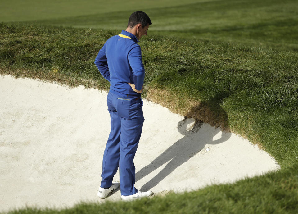 Europe's Rory McIlroy looks down at his ball in a bunker on the 18th hole during a singles match on the final day of the 42nd Ryder Cup at Le Golf National in Saint-Quentin-en-Yvelines, outside Paris, France, Sunday, Sept. 30, 2018. Europe's Rory McIlroy lost to Justin Thomas of the US. (AP Photo/Matt Dunham)