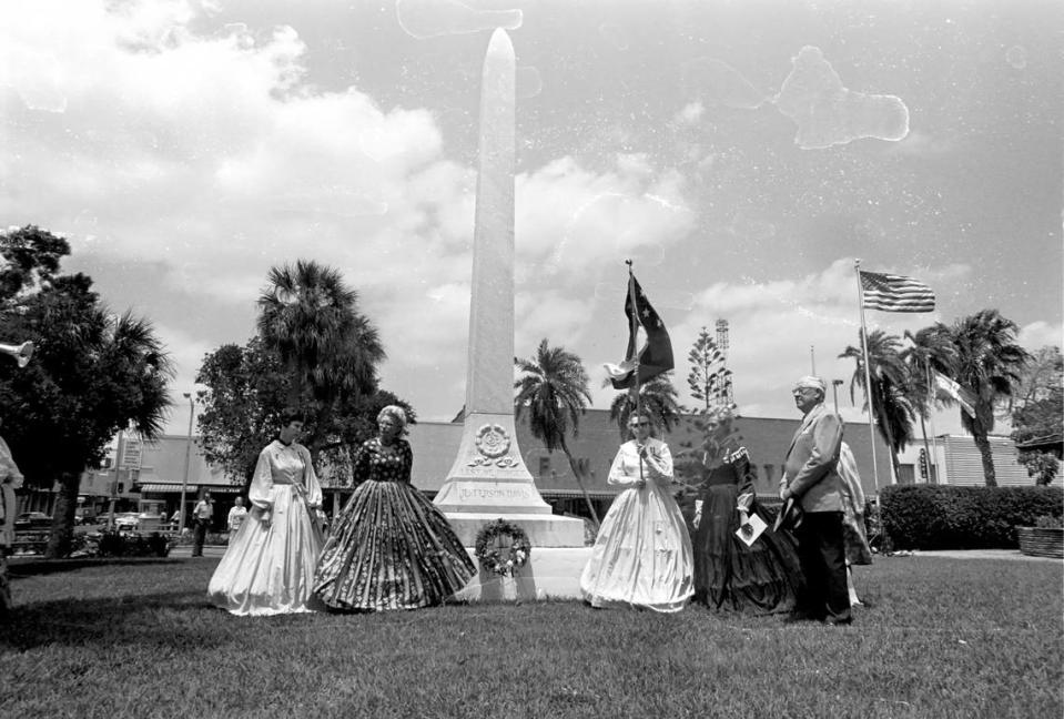 Four women from the United Daughters of the Confederacy, in long dresses, stand with a man in front of the Confederate Soldier’s monument on Courthouse Square in 1978. This was their traditional Confederate Memorial Day service and they placed a memorial wreath. The ladies decorate the graves of Civil War soldiers of both North and South.