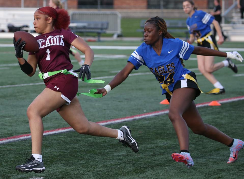 Greece Arcadia's Jazmin Matthews gains yards up the middle during a flag football game last season, but is stopped by Irondequoit's Abiola Koumassou who gets to her flag.