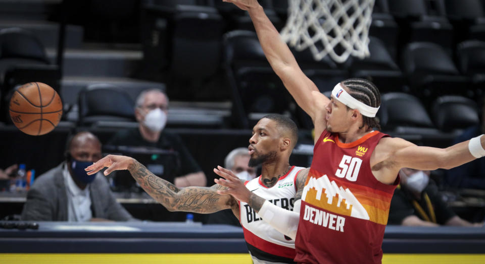 Portland Trail Blazers guard Damian Lillard (0) passes away from Denver Nuggets forward Aaron Gordon (50) in the third quarter of Game 2 of a first-round NBA basketball playoff series Monday, May 24, 2021, in Denver. (AP Photo/Joe Mahoney)