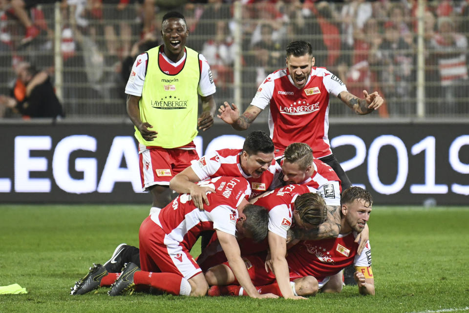 FC Union Berlin players celebrate after the soccer match with VfB Stuttgart in Berlin, Germany, Monday May 27, 2019. FC Union Berlin secured promotion to the Bundesliga. (Joerg Carstensen/dpa via AP)