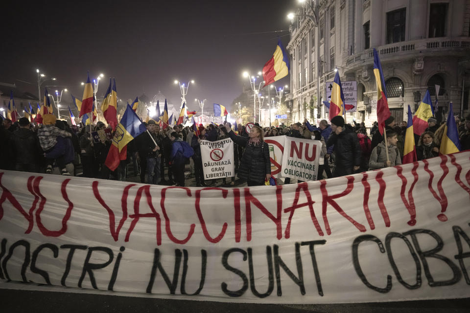 FILE - People hold a large banner that reads "No to Vaccination - Our Children are not your guinea pigs" during a protest against vaccinations, the introduction of the green pass and COVID-19 related restrictions in Bucharest, Romania, Sunday, Nov. 7, 2021. (AP Photo/Vadim Ghirda, File)