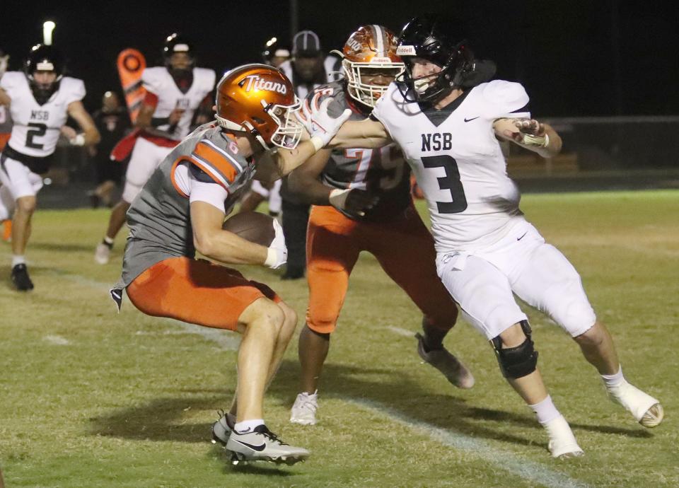 University High's Isaiah Baker (6) dodges New Smyrna Beach High's Sawyer Vanrider (3), Friday November 10, 2023.