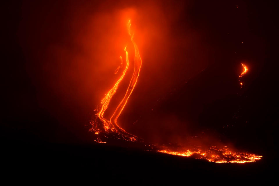 Mount Etna volcano spews lava during an eruption early Tuesday Dec. 25, 2018. Italy's Catania airport is reopening after an ash cloud from Mount Etna's latest eruptions forced it to shut down. The airport on the Mediterranean island of Sicily says it's having a limited opening Tuesday, operating four flights an hour. (Orietta Scardino/ANSA via AP)