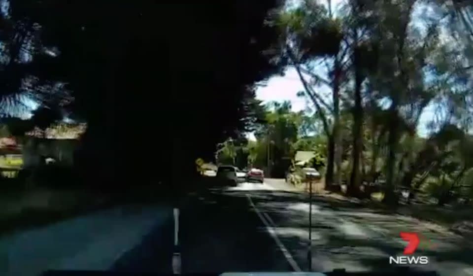 A driver overtakes another car as two police motorbikes approach from the opposite direction. Source: 7 News