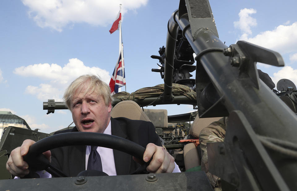 FILE - In this Thursday, June 21, 2018 file photo Britain's Foreign Secretary Boris Johnson talks to a British armed forces serviceman based in Orzysz, in northeastern Poland, during a ceremony at the Tomb of the Unknown Soldier and following talks on security with his Polish counterpart Jacek Czaputowicz in Warsaw, Poland. (AP Photo/Czarek Sokolowski, File)