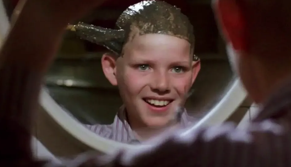 kid putting peanut butter on his head while looking in mirror