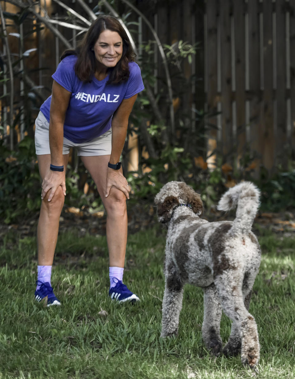 Michele Hall plays with her dog Beau in their backyard Thursday, June 24, 2021, in Bradenton, Fla. Hall, 54, diagnosed with early Alzheimer's last year, calls the new drug Aduhelm "the first tiny glimmer of hope" she'll get more quality time with her husband and their three adult children. (AP Photo/Steve Nesius)