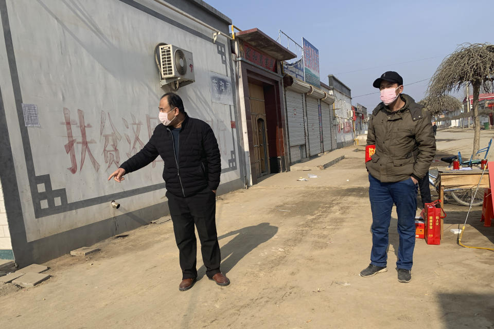 Men wearing face masks stand near a barricade at the entrance to Donggouhe village in northern China's Hebei Province, Wednesday, Jan. 29, 2020. With barricades and wary guardians, villages on the outskirts of Beijing are closing themselves off to outsiders to ward against infection amid the outbreak of a new type of virus. (AP Photo)