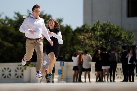 News assistants run outside the U.S. Supreme Court in Washington