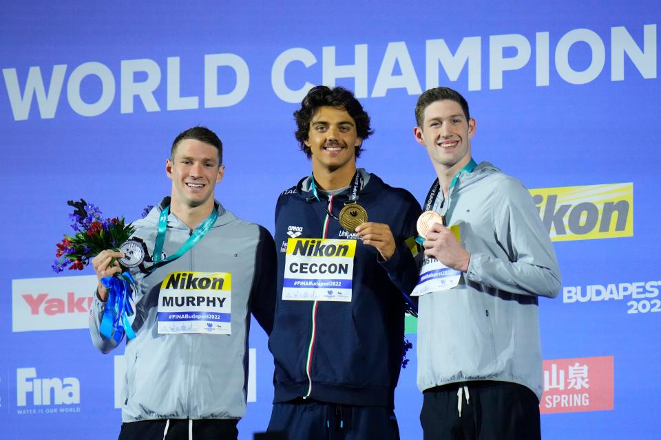 Silver medalist Ryan Murphy of the United States, gold medalist Thomas Ceccon of Italy and Hunter Armstrong of the United States, from left to right, pose with their medals after the Men 100m Backstroke final at the 19th FINA World Championships in Budapest, Hungary, Monday, June 20, 2022.
