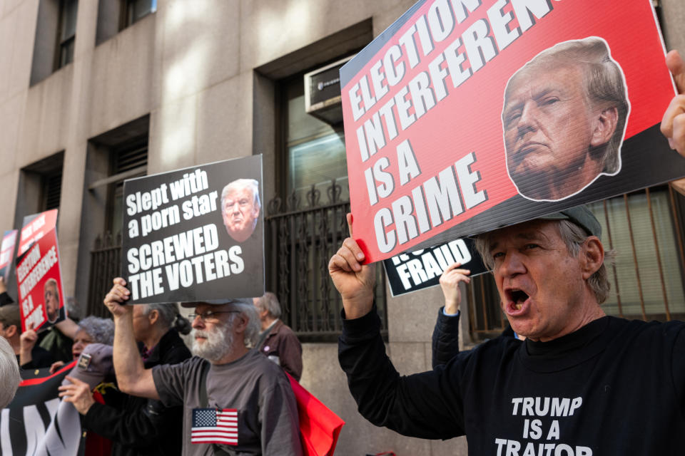 Protesters holding signs with political messages against a person whose name cannot be disclosed