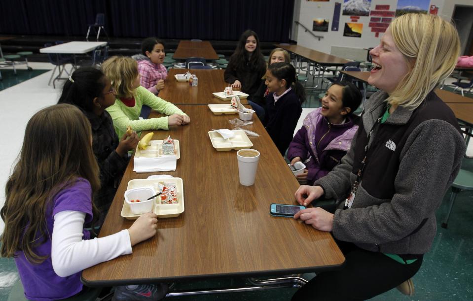 Art teacher, Leigh Walker, entertains students over breakfast that spent the night at Oak Mountain Intermediate school on Wednesday, Jan. 29, 2014, in Indian Springs, Ala. About 80 children and 20 adults spent the night at the school due to a winter storm. Tuesday's storm deposited mere inches of snow, barely enough to qualify as a storm up North. And yet it was more than enough to paralyze the Deep South. (AP Photo/Butch Dill)