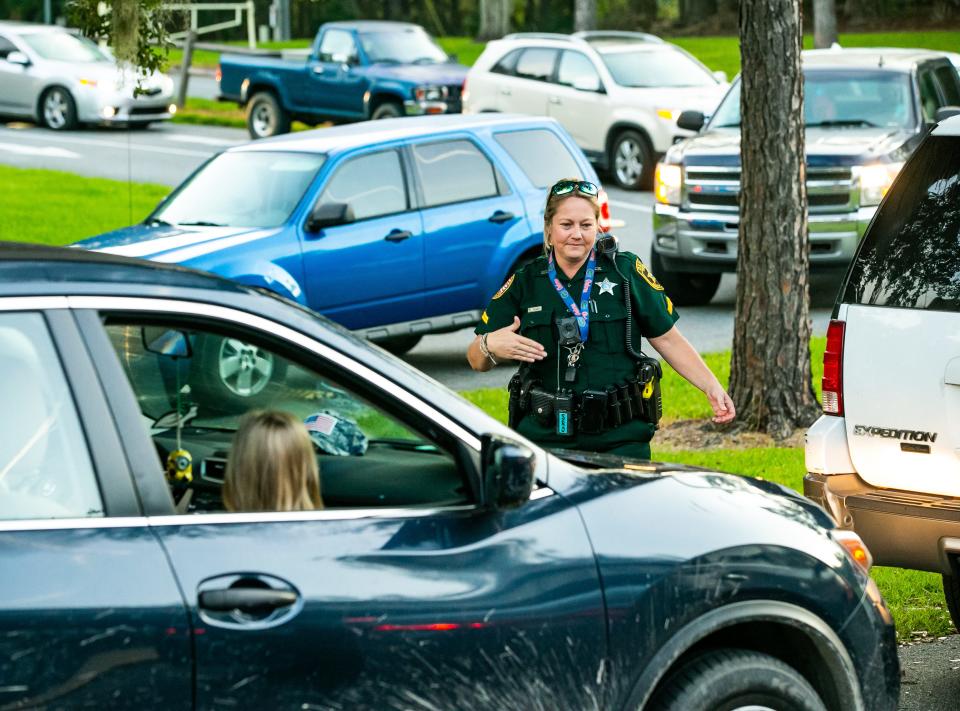 Shady Hill Elementary School Resource Officer Rochelle Mims directs parents to move forward in car line on first day of school in August.