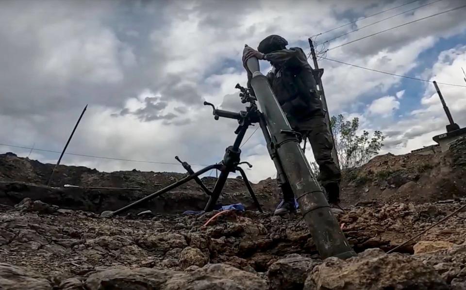 A Russian soldier firing a mortar during fighting in Kharkiv - Russian Defence Ministry Press Service/EPA-EFE/Shutterstock 